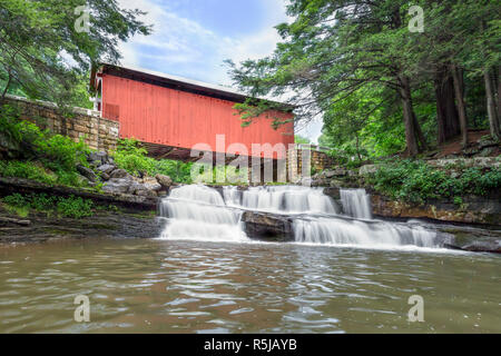 Built in 1887, the historic Packsaddle Covered Bridge crosses over a waterfall on Brush Creek in rural Somerset County, Pennsylvania. Stock Photo