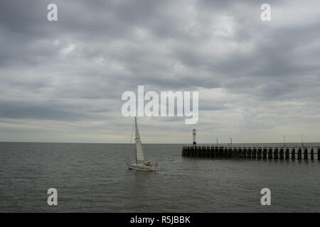 Sailing boat leaving the harbour of Nieuwpoort West Flanders Belgium Stock Photo