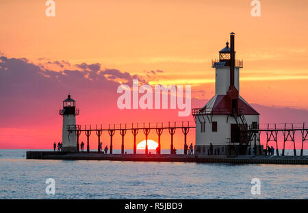 On the Summer Solstice, the sun sets on Lake Michigan between the Inner and Outer North Pier Lighthouses at St. Joseph, Michigan. Stock Photo