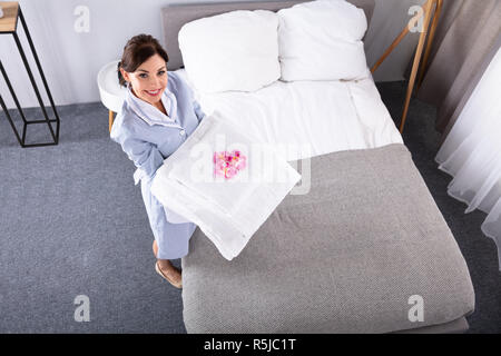 Portrait Of A Happy Young Woman With Stack Of White Towels Stock Photo