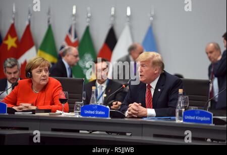 Buenos Aires, Argentina. 1st December, 2018. Argentina. 1st December 2018. U.S. President Donald Trump, right, address the plenary session on Day Two of the G20 Summit meeting as German Chancellor Angela Merkel, left, looks on at the Costa Salguero Center December 1, 2018 in Buenos Aires, Argentina. Credit: Planetpix/Alamy Live News Credit: Planetpix/Alamy Live News Stock Photo