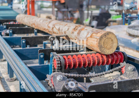 portable saw mill cutting a log into boards Stock Photo 