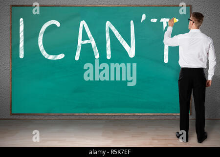 Businessman Rubbing Letter T From I Can't Written On Chalkboard Stock Photo