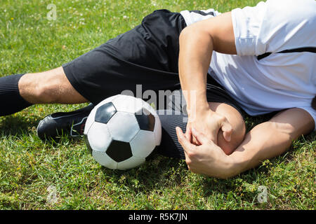 Male Soccer Player Suffering From Knee Injury Stock Photo