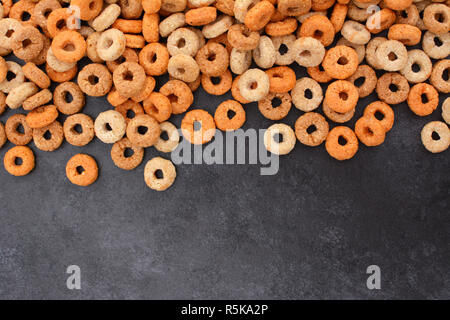 Multigrain hoops breakfast cereal border on dark grey slate Stock Photo