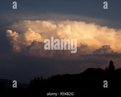 towering dense cumulo-nimbus clouds ('The King of Clouds') bringing thunderstorms produce dramatic chiaroscuro skyscape over Tuscany, Italy Stock Photo
