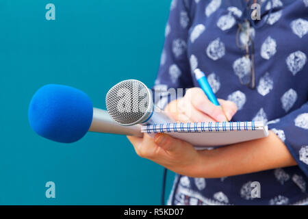 Female journalist taking notes at press conference Stock Photo