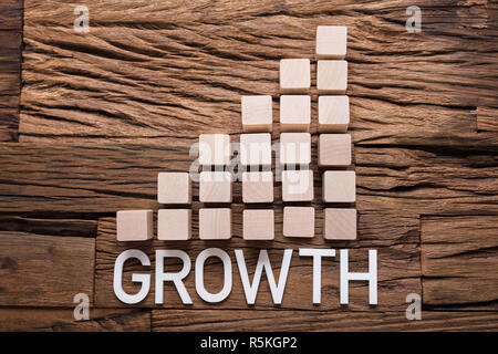 Growth Text By Increasing Bar Graph Blocks On Wood Stock Photo