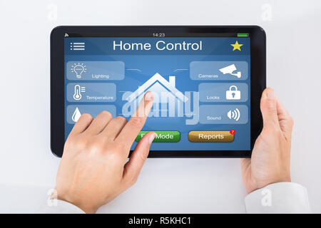 Person Using Home Control System On Digital Tablet Stock Photo