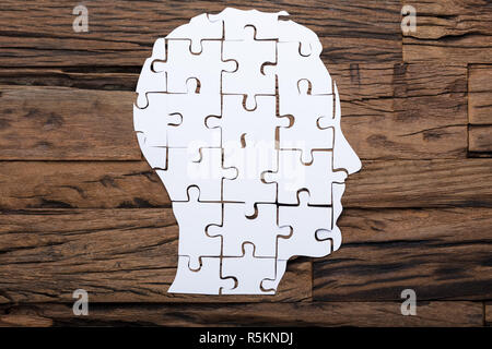 Businessman's Head Made From Paper Jigsaw Puzzle Pieces On Table Stock Photo