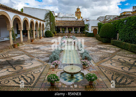 The Patio of the Columns at the Viana Palace in Cordoba, Spain, with its mosaic walkways, fountains, columns and flowers. Stock Photo