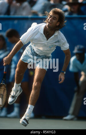 Andre Agassi following through on a serve during a match at the 1988 US Open at Flushing Meadows. Stock Photo