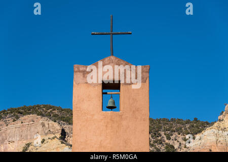Bell tower and rustic wood cross of the Abbey Church under a perfect blue sky at the Monastery of Christ in the Desert near Abiquiu, New Mexico Stock Photo