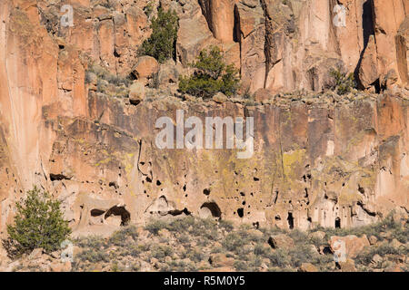 Ancient dwellings and abandoned ruins in a colorful cliff face  in Bandelier National Monument Stock Photo