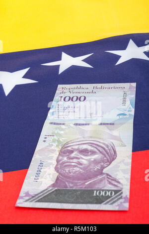 Venezuela flag with worthless Bolivar fuerte ('strong') banknote - for Hyperinflation in Venezuela economy. SEE ADDIT. NOTES Stock Photo