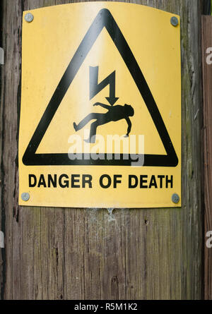 yellow danger of death sign on wooden post Stock Photo