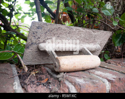 a plastering tool flat trowel resting on a wall Stock Photo