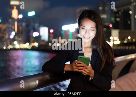 Business woman using mobile phone in Hong Kong city Stock Photo