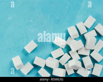 Top view of white sugar cubes on blue concrete background Stock Photo