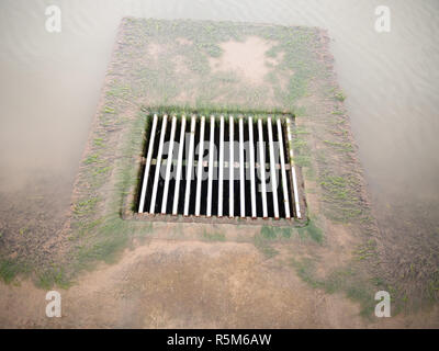 metal water grid with water running into it on ground clear Stock Photo