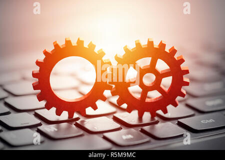 Gears on computer keyboard Stock Photo