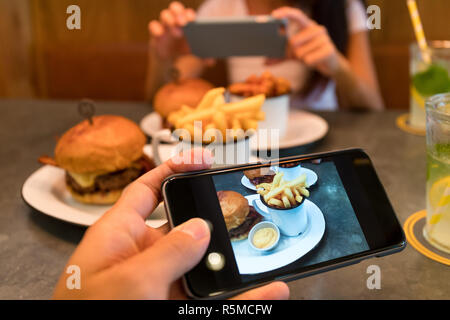 Taking photo on cellphone in restaurant Stock Photo