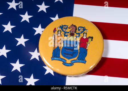 London, UK - November 15th 2018: The coat of arms of the State of New Jersey, pictured over the flag of the United States of America. Stock Photo