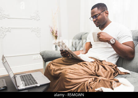 Young African American businessman remotely working at home on a laptop. Stock Photo
