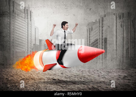 Asian business man riding rocket Stock Photo