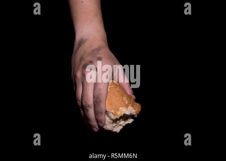 Poverty concept. Hands holding bread isolated on balck background. Stock Photo