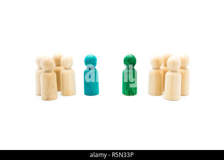 Wooden figures in line as business team, with blue and green figures standing out from the crowd, isolated on white background. Conceptual image of le Stock Photo