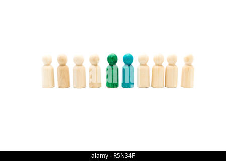 Wooden figures in line as business team, with blue and green figures standing out from the crowd, isolated on white background. Conceptual image of le Stock Photo