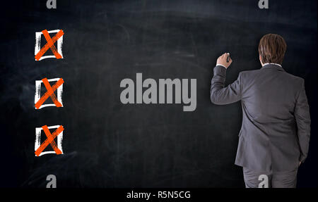 businessman is writing with checkbox concept on blackboard Stock Photo