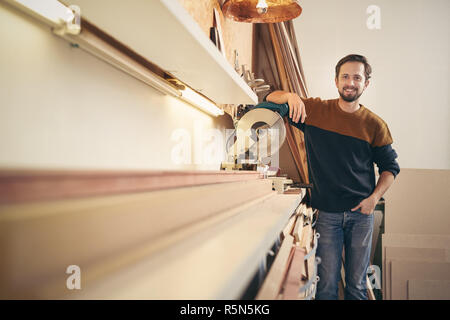 Professional framer standing proudly alongside a specialised wor Stock Photo