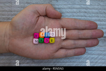 handmade letter cube in hand on gray wooden visualization Stock Photo