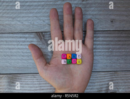 handmade letter cube in hand on gray wooden visualization Stock Photo