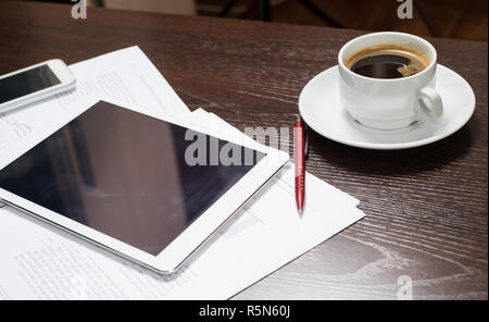 Workplace of businessman with digital tablet, smartphone, Cup of coffee and charts. The concept of a startup business Stock Photo