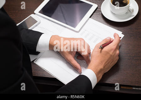 Businessman using digital tablet with charts for planning and analysis of business models, startup. Business Finance and money concept, the concept of investment Stock Photo