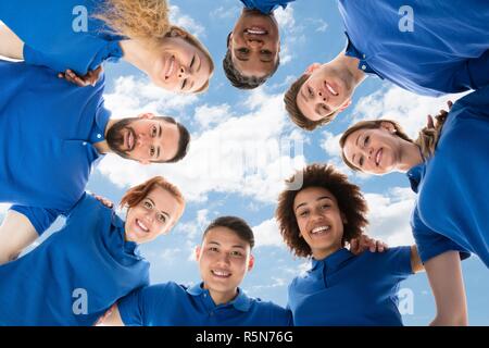 Happy Multiracial Janitors Forming Huddle Stock Photo