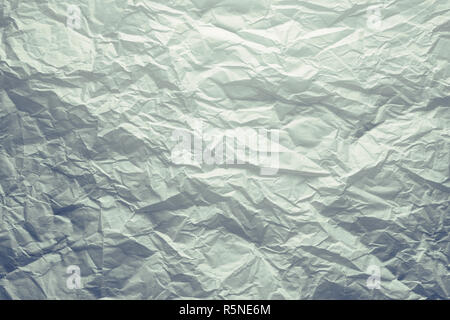 Wrinkled white paper texture background under dramatic dark moody lighting Stock Photo