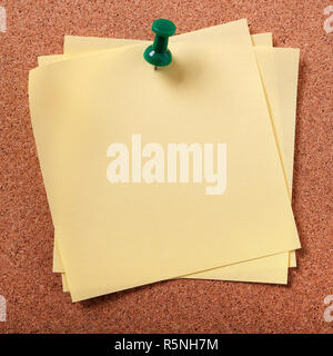 Several untidy sticky post notes pinned to cork board Stock Photo