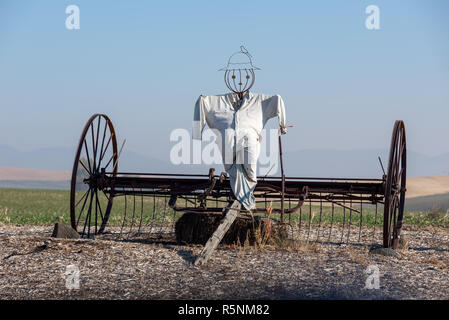 Scarecrow on an old horse drawn hay rake, Eastern Washington. Stock Photo