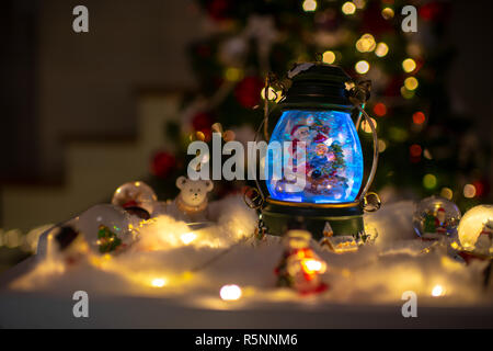Christmas scene, Santa with child on a sleigh in snow dome with reindeer, polar bears and snowmen domes and candles, illuminated christmas tree in Stock Photo