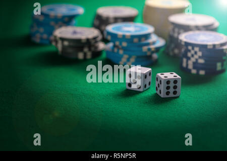 Casino, gambling concept. Poker chips piles and dice on green felt background, copy space Stock Photo