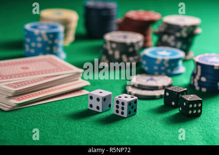 Casino, gambling concept. Poker chips piles, playing cards and dice on green felt background Stock Photo