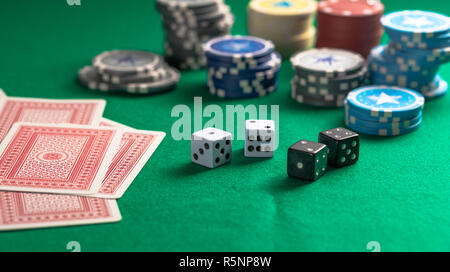 Casino, gambling concept. Poker chips piles, playing cards and dice on green felt background Stock Photo