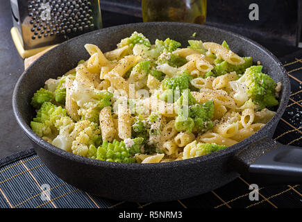 Penne pasta with cabbage romanesco on black table. Vegetarian food. Italian menu. Stock Photo