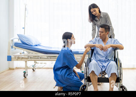 Physical therapist explain treatment method to senior patient and relative Stock Photo