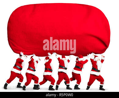 many Santa claus carrying big and heavy gift red sack Stock Photo