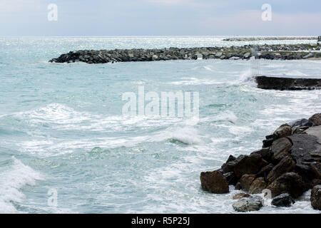 Waves breaking onto a stony seashore. Close-up. Stock Photo